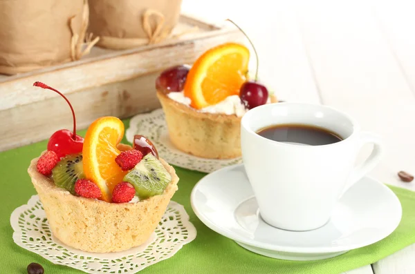 Tasse de café et gâteaux sucrés avec des fruits sur la table en bois — Photo