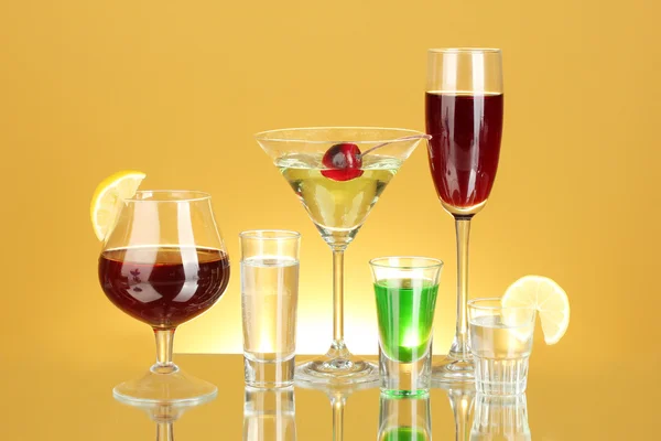 Una variedad de bebidas alcohólicas sobre fondo amarillo —  Fotos de Stock