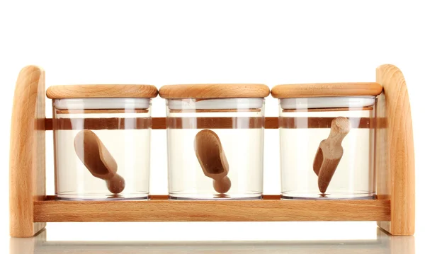 Lege glazen potten voor specerijen met lepels op houten plank geïsoleerd op wit — Stockfoto