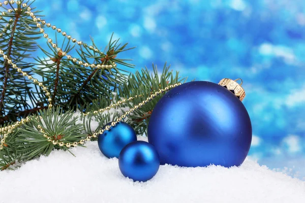Christmas ball and green tree in the snow on blue — Stock Photo, Image