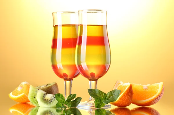 Ζελέ φρούτων στα γυαλιά και τα φρούτα σε κίτρινο φόντο — Φωτογραφία Αρχείου