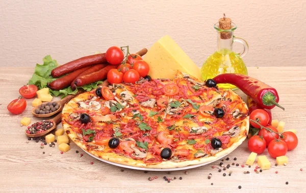 Heerlijke pizza, groenten en salami op houten tafel — Stockfoto