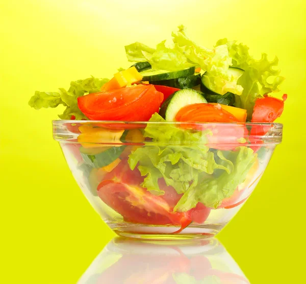 Fresh vegetable salad in transparent bowl on green background — Stock Photo, Image