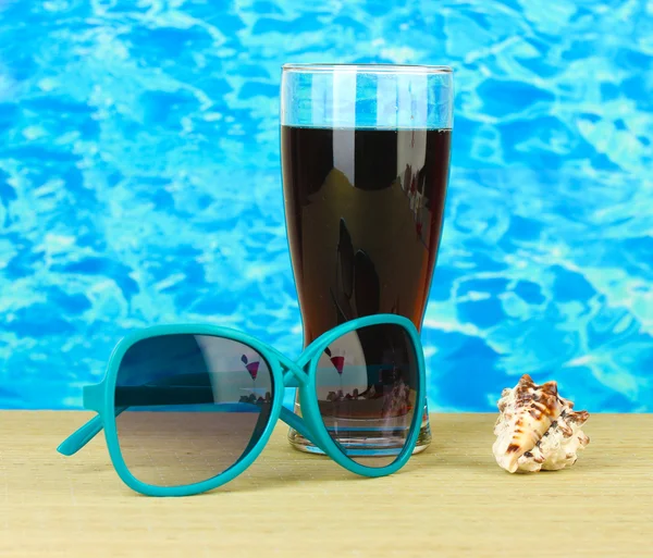 Composición de playa de gafas de sol de mujer de moda y una bebida refrescante —  Fotos de Stock