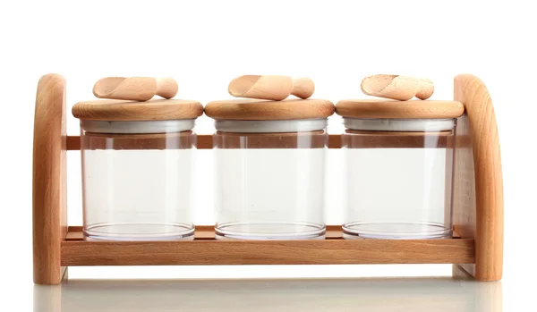 Puste szklane pojemniki do przypraw z łyżki na drewnianej półce na białym tle — Zdjęcie stockowe