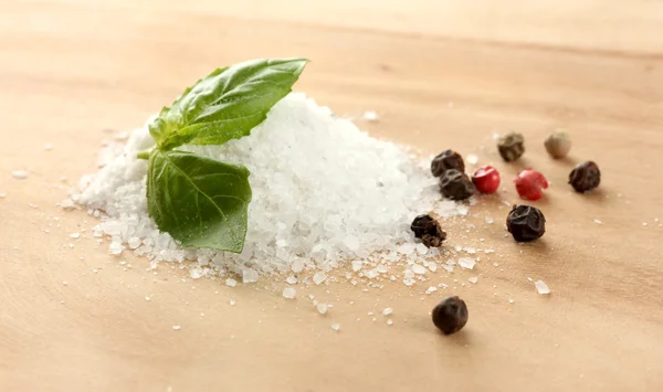 Salt och peppar med färsk basilika på träbord — Stockfoto