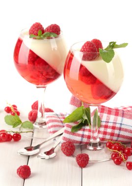 Fruit jelly with berries in glasses on wooden table clipart