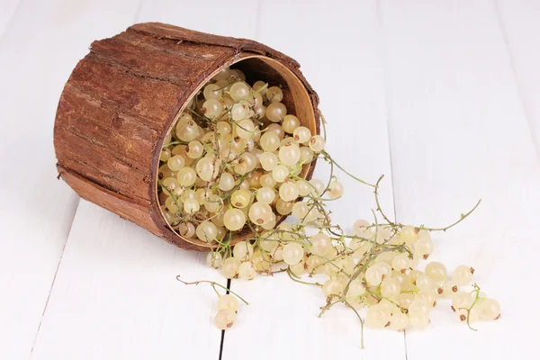 White currants in wooden cup on wooden background — Stok fotoğraf
