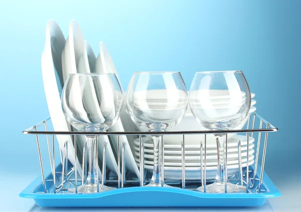 Clean dishes on stand on blue background — Stock Photo, Image