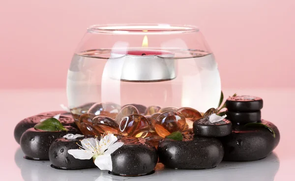 Komposition der Vase mit Kerze und Wellness-Steinen auf rotem Hintergrund — Stockfoto