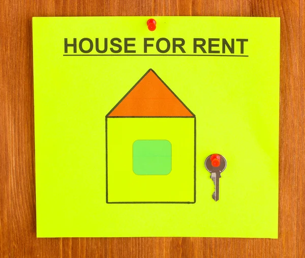 Плакат об аренде дома с ключом на деревянном фоне крупным планом — стоковое фото