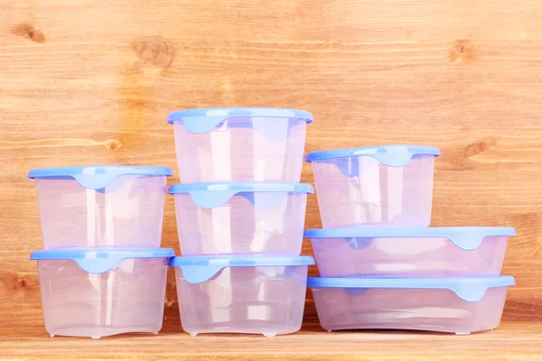 Plastic verpakkingen voor voedsel op houten achtergrond — Stockfoto
