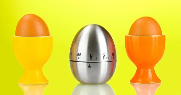 Eieruhr und Ei in Farbe stehen auf grünem Hintergrund — Stockfoto