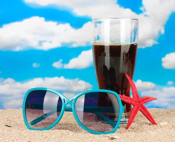 Strandkomposition aus modischen Sonnenbrillen für Frauen und einem erfrischenden Getränk — Stockfoto