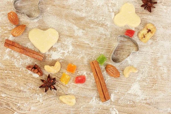 Frutas cristalizadas, nozes, biscoitos não cozidos e moldes para biscoitos em uma mesa de madeira close-up — Fotografia de Stock