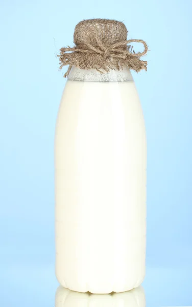 Μπουκάλι γάλα σε κοντινό πλάνο μπλε φόντο — Φωτογραφία Αρχείου