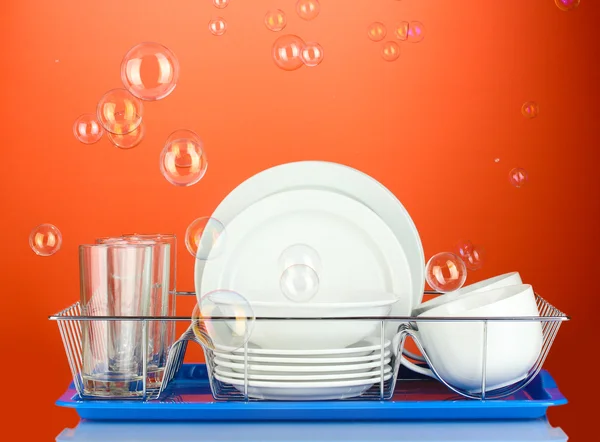 Clean dishes on stand on red background — Stock Photo, Image