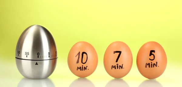 Χρονόμετρο αυγό και τα αυγά τους σε πράσινο φόντο — Φωτογραφία Αρχείου