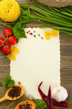 Paper for recipes vegetables, and spices on wooden table clipart