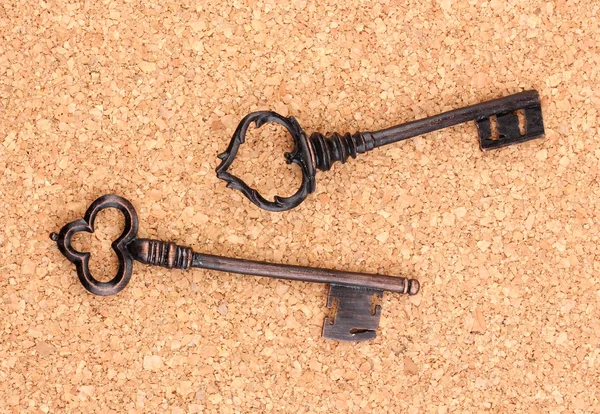 Dwie zabytkowe klucze na tle korka — Zdjęcie stockowe