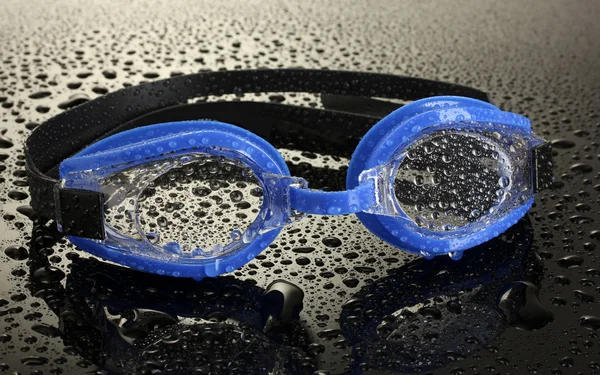 Blauwe zwemmen bril met druppels op grijze achtergrond — Stockfoto