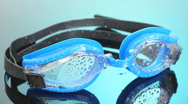 Blå simma glasögon med droppar på blå bakgrund — Stockfoto