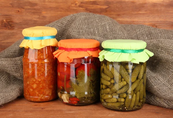 Jars with canned vegetables on wooden background close-up — Stock Photo, Image
