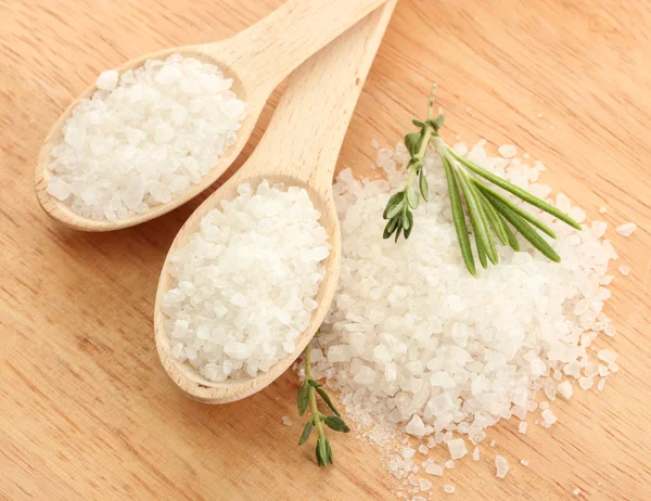 Salz in Löffeln mit frischem Rosmarin und Thymian auf Holzgrund — Stockfoto