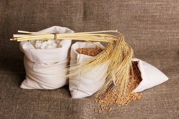 Зерно муки и пшеницы на мешковине — стоковое фото