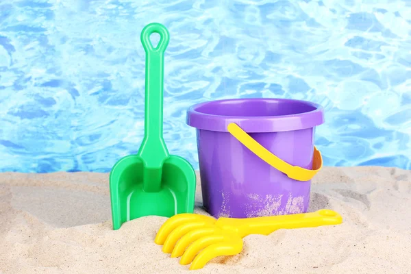 stock image Children's beach toys on sand on water background