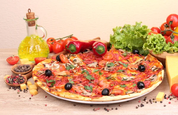 Délicieuse pizza et légumes sur table en bois — Photo