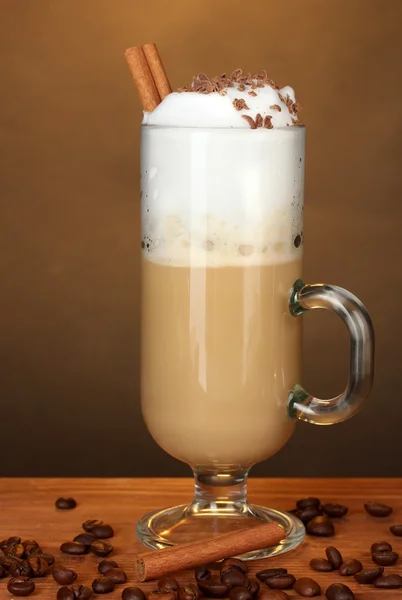 Kieliszek kawy koktajlowe z ziaren kawy na brązowym tle — Zdjęcie stockowe