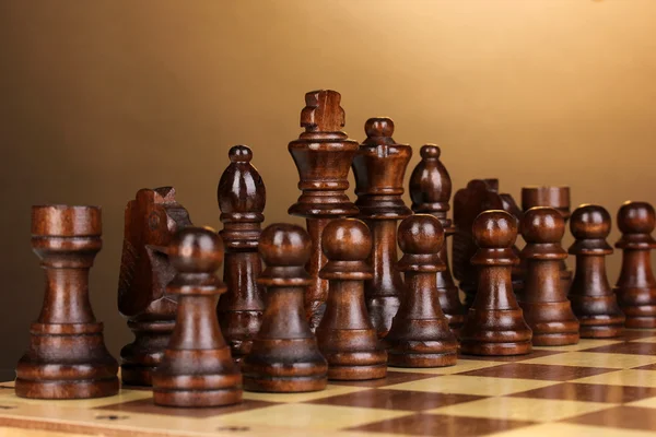 Шахматная доска с шахматами на коричневом фоне — стоковое фото