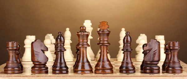 Satranç taşları üzerinde kahverengi zemin ile satranç masası — Stok fotoğraf