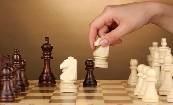Schachbrett mit Schachfiguren auf braunem Hintergrund — Stockfoto
