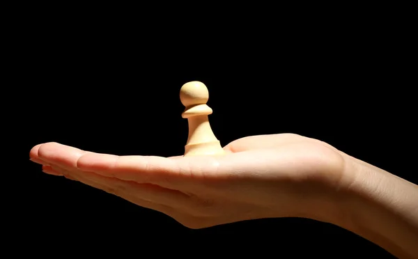 stock image Chess piece in hand isolated on black