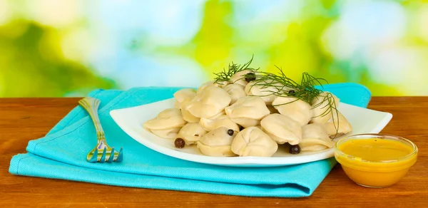 Deliziosi gnocchi cotti nel piatto su sfondo verde brillante — Foto Stock