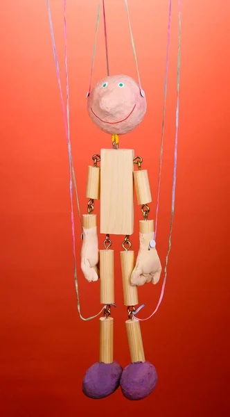 Trä marionett på röd bakgrund — Stockfoto