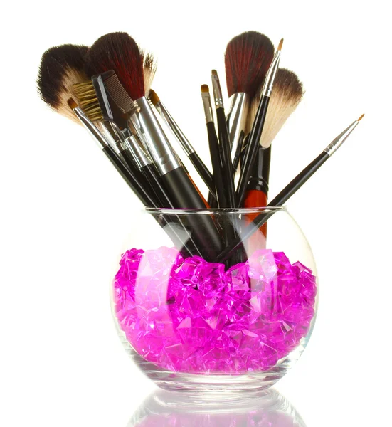 Cepillos de maquillaje en un tazón con piedras aisladas en blanco — Foto de Stock