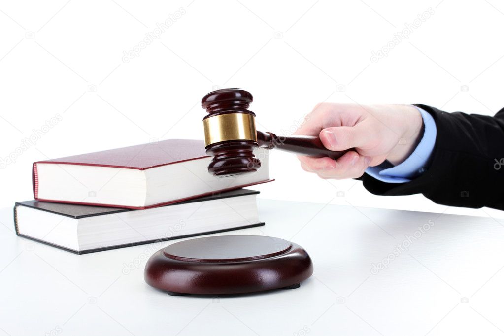 Wooden gavel in hand and books isolated on white