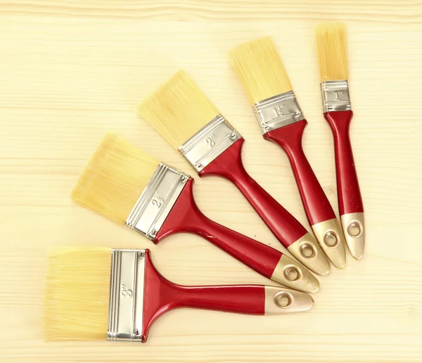 Paint brushes on wooden background — Stock Photo, Image