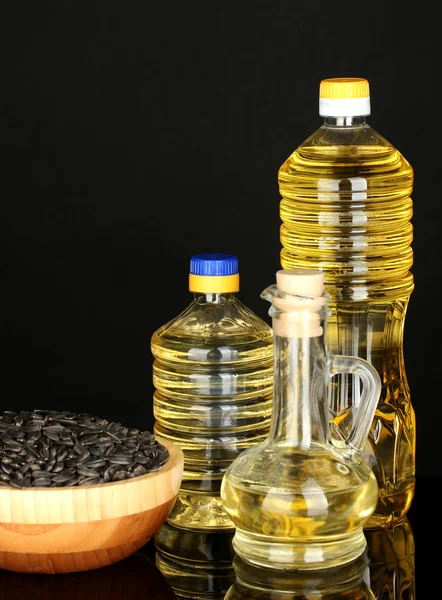 Óleo de girassol em garrafas no fundo preto close-up — Fotografia de Stock