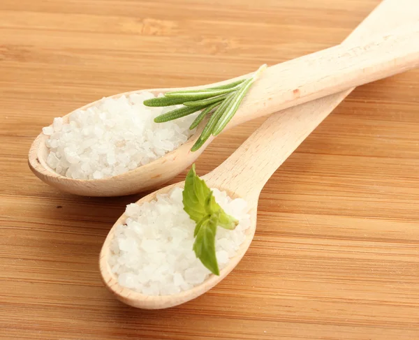 Sůl v lžíce s čerstvým rozmarýnem a bazalkou na dřevěné pozadí — Stock fotografie