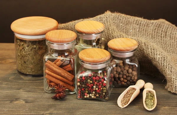 罐子和勺子用棕色背景上的木桌上的香料 — 图库照片