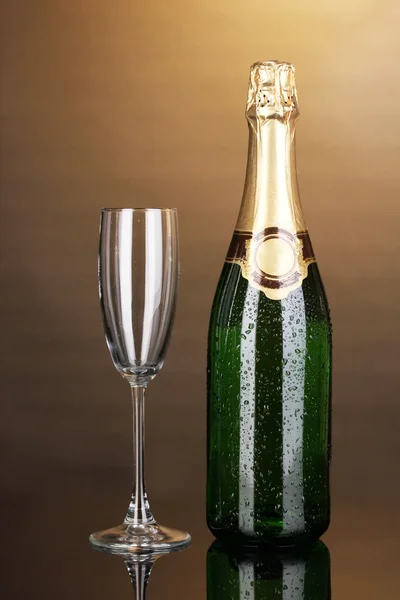 Botella de champán y copa sobre fondo marrón — Foto de Stock