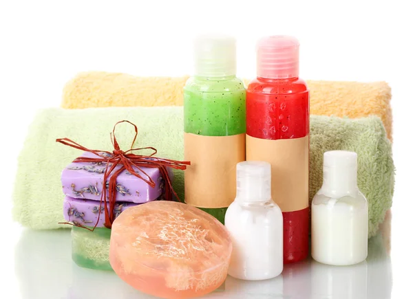 Bottles with scrub, soaps and towels isolated on white — Stock Photo, Image