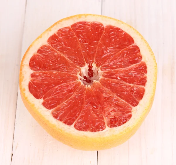 Половина спелого грейпфрута на деревянном фоне — стоковое фото