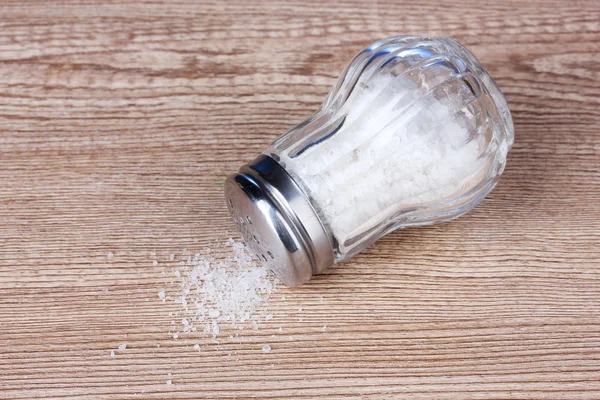 Cave à sel en verre avec sel sur fond en bois — Photo