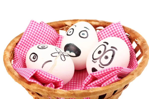 Witte eieren met grappige gezichten in mand geïsoleerd op wit — Stockfoto