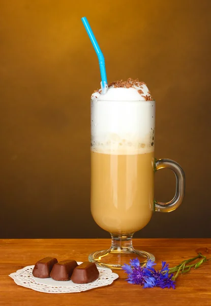 Glas kaffe cocktail med choklad godis på doily på brun bakgrund — Stockfoto